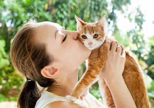 Woman is kissing cat